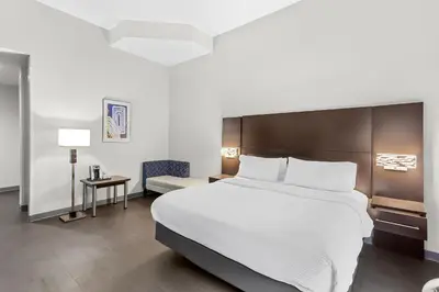 a bedroom with a large bed and a chair at Holiday Inn Express & Suites Cross Lanes by IHG in Cross Lanes
