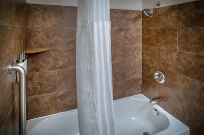 a bathroom with a shower and a white tub at Holiday Inn Express & Suites Cross Lanes by IHG in Cross Lanes