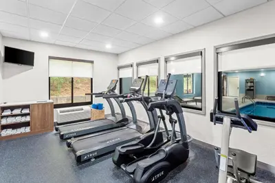 a gym with cardio machines and a swimming pool at Holiday Inn Express & Suites Cross Lanes by IHG in Cross Lanes