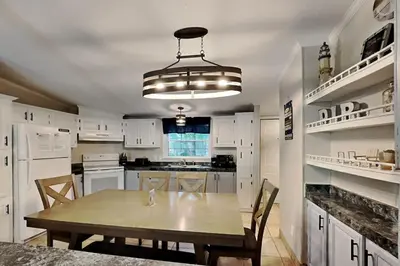 a kitchen with white cabinets and a table with chairs at Put-in-Bay Island Club #27 in Put-in-Bay