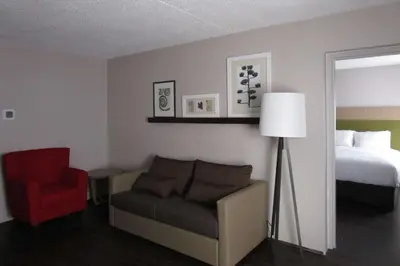 a hotel room with a bed and a couch and a chair at Country Inn & Suites by Radisson, Dunbar - Charleston in Dunbar