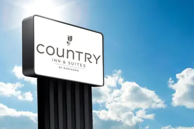 a sign for a country inn and suites at Country Inn & Suites by Radisson, Dunbar - Charleston in Dunbar