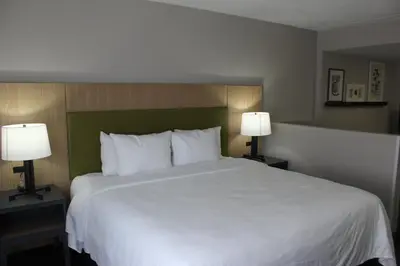 a bedroom with a large white bed with two lamps at Country Inn & Suites by Radisson, Dunbar - Charleston in Dunbar