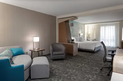 a hotel room with a bed and a couch at Courtyard Cincinnati Mason in Mason