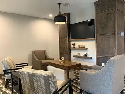a waiting room with chairs and a table and a tv at Staybridge Suites Florence - Cincinnati South by IHG in Florence
