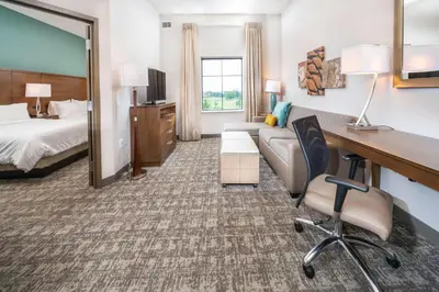 a hotel room with a bed and a desk at Staybridge Suites Florence - Cincinnati South by IHG in Florence