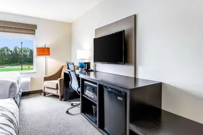 a hotel room with a desk with a flat screen tv at Sleep Inn Winfield - Teays Valley in Hurricane