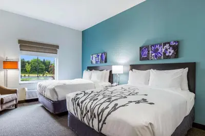 a hotel room with two beds and a window at Sleep Inn Winfield - Teays Valley in Hurricane