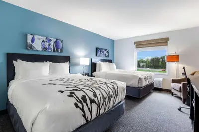 a hotel room with two beds and a window at Sleep Inn Winfield - Teays Valley in Hurricane