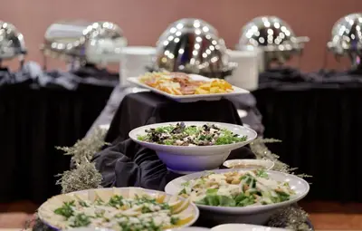 a buffet with bowls of food on a table at BLU-Tique, Akron, a Tribute Portfolio Hotel in Akron