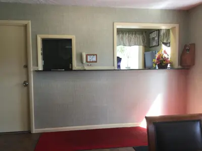 a room with a wall with a counter and a mirror at FALLS INN in Newton Falls