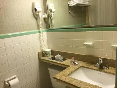 a bathroom with a sink and a phone on the wall at FALLS INN in Newton Falls