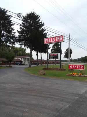 a sign for a falls inn on a street at FALLS INN in Newton Falls