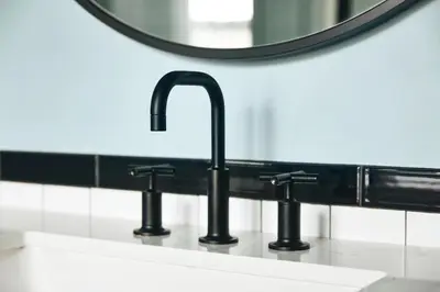 a bathroom sink with three faucets and a mirror at Kinley Cincinnati Downtown, a Tribute Portfolio Hotel in Cincinnati