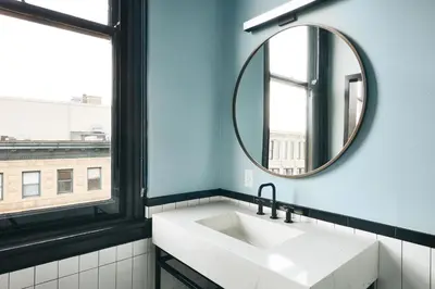 a bathroom with a sink and a mirror at Kinley Cincinnati Downtown, a Tribute Portfolio Hotel in Cincinnati