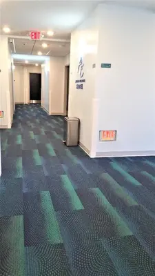 an empty hallway in an office building with green lines on the floor at Athens Central Hotel in Athens