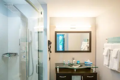 a bathroom with a sink and a shower with a mirror at Athens Central Hotel in Athens