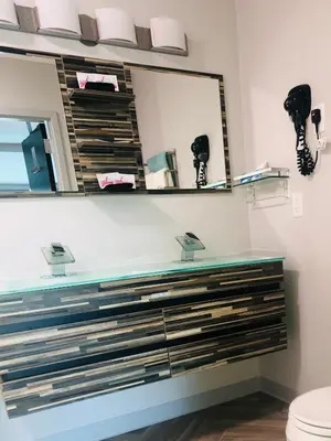 a bathroom with a mirror and a sink at Athens Central Hotel in Athens