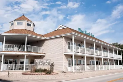 a large white building with a sign in front of it at West Bank Inn in Celina