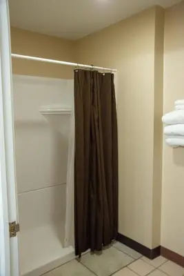 a bathroom with a shower curtain in a closet at West Bank Inn in Celina
