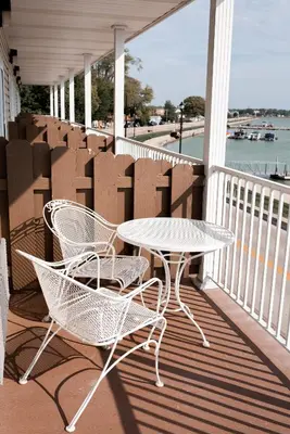 two chairs and a table on a porch with boxes at West Bank Inn in Celina