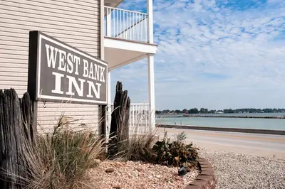 a sign for the west bank bank inn next to a house at West Bank Inn in Celina