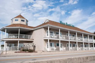 a large white building with a sign on the roof at West Bank Inn in Celina