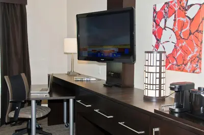 a room with a desk with a tv and a chair at Holiday Inn Express & Suites Columbus - Easton Area by IHG in Gahanna