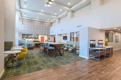 a lobby with tables and chairs and a cafeteria at Hampton Inn & Suites Cincinnati Liberty Township in West Chester