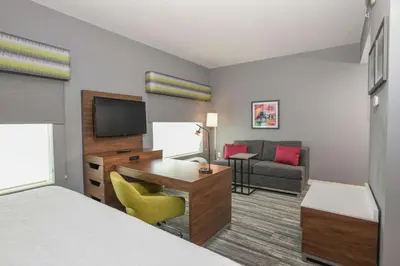 a hotel room with a bed and a desk and a television at Hampton Inn & Suites Cincinnati Liberty Township in West Chester