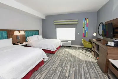 a hotel room with two beds and a flat screen tv at Hampton Inn & Suites Cincinnati Liberty Township in West Chester