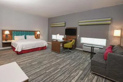 a hotel room with a bed and a desk and a couch at Hampton Inn & Suites Cincinnati Liberty Township in West Chester