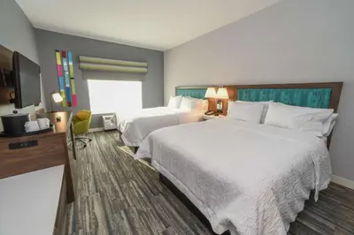 a hotel room with two beds and a television at Hampton Inn & Suites Cincinnati Liberty Township in West Chester
