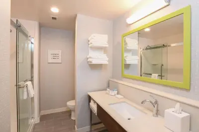 a bathroom with a sink and a mirror and a toilet at Hampton Inn & Suites Cincinnati Liberty Township in West Chester