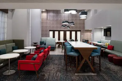 a waiting room with tables and chairs and tablesktop at Hampton Inn & Suites Adrian, Mi in Adrian