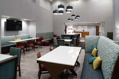 a waiting room with tables and couches and chairs at Hampton Inn & Suites Adrian, Mi in Adrian