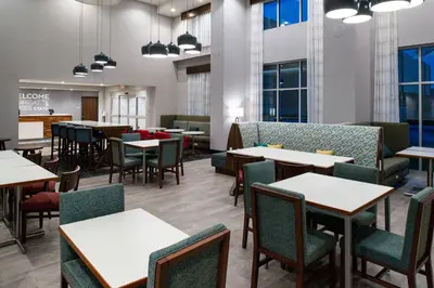 a dining room with tables and chairs and windows at Hampton Inn & Suites Adrian, Mi in Adrian