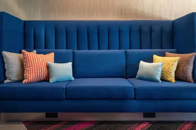 a blue couch with colorful pillows on it at Tru By Hilton Sharonville, OH in Cincinnati