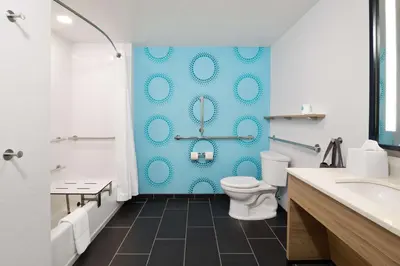 a bathroom with a toilet and a blue wall at Tru By Hilton Sharonville, OH in Cincinnati