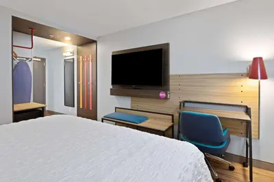 a hotel room with a bed and a tv and chairs at Tru By Hilton Sharonville, OH in Cincinnati