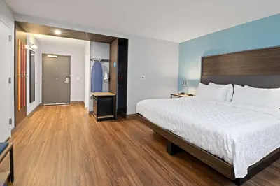 a bedroom with a large white bed and wooden floors at Tru By Hilton Sharonville, OH in Cincinnati