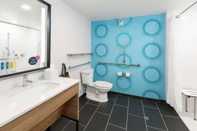 a bathroom with a toilet and a blue wall at Tru By Hilton Sharonville, OH in Cincinnati
