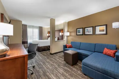 a hotel room with a couch and a bed at Comfort Suites Dry Ridge in Dry Ridge