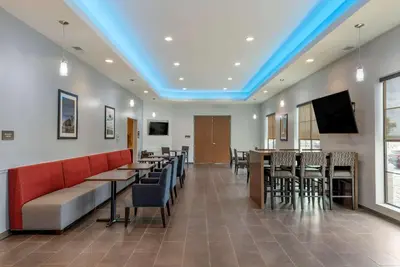 a restaurant with tables and chairs and a blue ceiling at Comfort Suites Dry Ridge in Dry Ridge