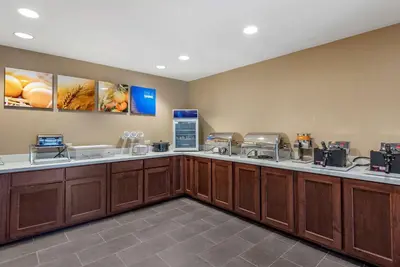 a kitchen with wooden cabinets and a counter top at Comfort Suites Dry Ridge in Dry Ridge