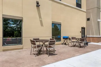 a patio with tables and chairs in front of a building at Comfort Suites Dry Ridge in Dry Ridge