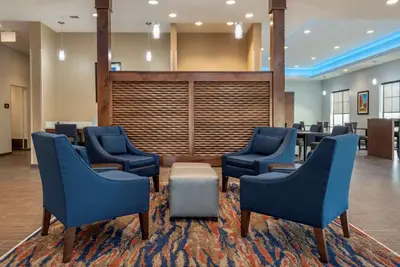 a waiting room with blue chairs and a table and a conference room at Comfort Suites Dry Ridge in Dry Ridge
