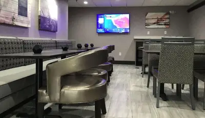 a dining room with a table and chairs and a tv at Best Western Lexington Inn in Lexington