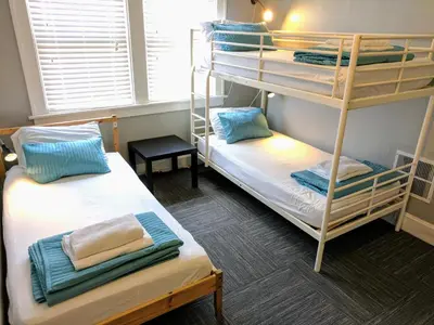 a room with two bunk beds and a window at The Wayfaring Buckeye Hostel in Columbus