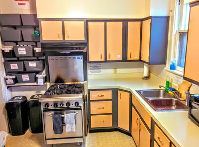 a small kitchen with a stove and a sink at The Wayfaring Buckeye Hostel in Columbus